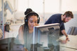 © Tom Merton/Caia Image - Female engineer with headphones using computer in office