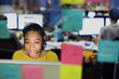© Tom Merton/Caia Image - Businesswoman with headset working at computer behind adhesive notes