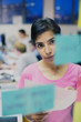 © Tom Merton/Caia Image - Focused businesswoman planning, looking at adhesive notes in office