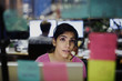 © Tom Merton/Caia Image - Businesswoman with headset looking at adhesive notes, planning in office