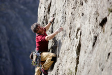Male Rock Climber Scaling Rock Face