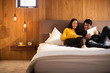 © Tom Merton/Caia Image - Couple reading book and using digital tablet in bed