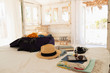 © Paul Bradbury/Caia Image - Suitcase, sun hat, sunglasses, book and digital tablet on beach house bed