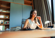 © Paul Bradbury/Caia Image - Smiling female interior designer with headset working in home office