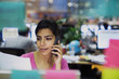 © Tom Merton/Caia Image - Businesswoman talking on smart phone and reading paperwork in office