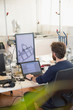 © Tom Merton/Caia Image - Male engineer programming robotics, working at laptop in office