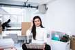 © Sam Edwards/Caia Image - Portrait confident businesswoman using laptop in new office