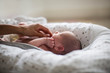 © Sam Edwards/Caia Image - Mother touching cute newborn baby son in bassinet