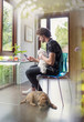 © Tom Merton/Caia Image - Young man with dogs working at desk in home office
