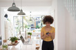 © Sam Edwards/Caia Image - Young female freelancer using smart phone in kitchen