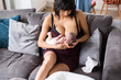 © Sam Edwards/Caia Image - Mother breastfeeding newborn baby son on sofa