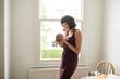 © Sam Edwards/Caia Image - Mother holding newborn baby son at window