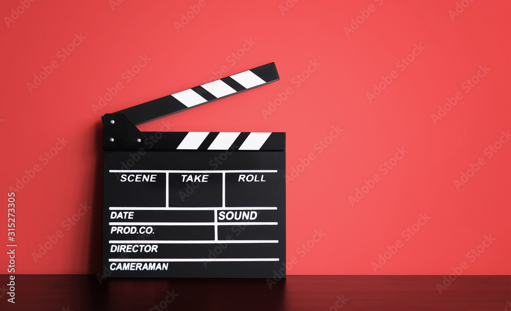 Blank Film clapper board or movie clapper cinema board , Slate film on black wooden with red wall background .cinema concept - obrazy, fototapety, plakaty 