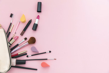 make-up cosmetic bag against pink background, copy space