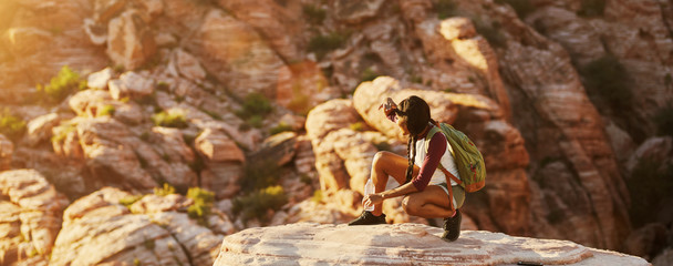 Wall Mural - athletic african american woman backpacker on top of tall cliff at red rock canyon nevada