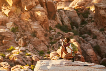 Wall Mural - woman hiker at red rock canyon drinking from water bottle