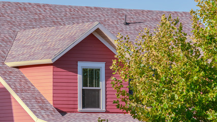 Panorama frame Colourful red timber clad house in green trees