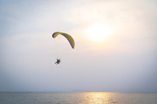 A Man Is Flying With A Powered Parachute Over The Beach In Thailand.