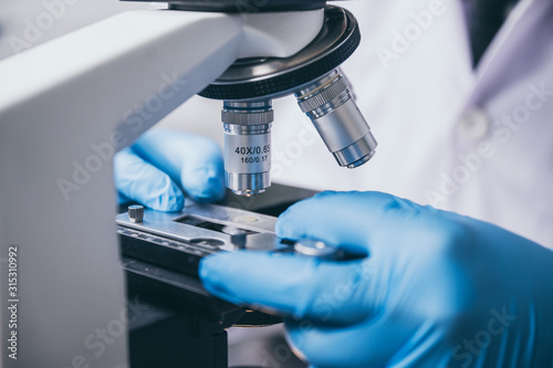 Fotografía Young scientist looking through a microscope in a laboratory