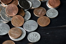 American Cents Coins Are Scattered On A Black Wooden Surface. Money Background