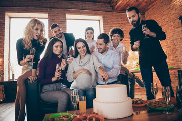 Wall Mural - Photo of group best friends came to visit married couple waiting baby born arranging surprise baby party bring big cake going to eat wear formalwear room indoors