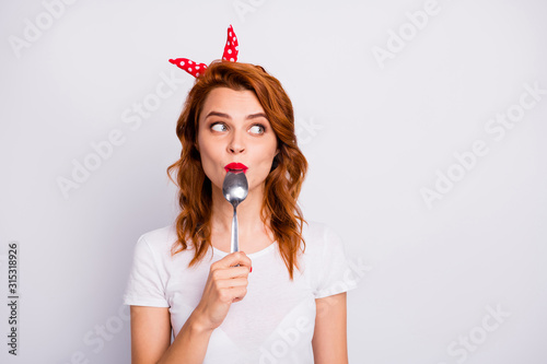 Fotomural Portrait of astonished girl lick spoon hold hand look copyspace impressed with y