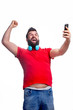 © Yehor Serdiuk - a man in a red T-shirt with a beard and headphones holds a phone in his hands
