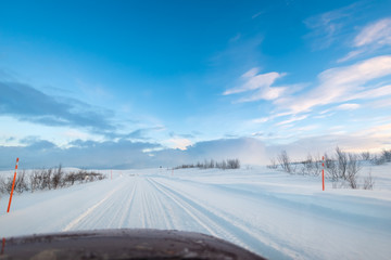 Wall Mural - road trip in the arctic on a snow covered ice road with car hood / bonnet visible at the bottom of t