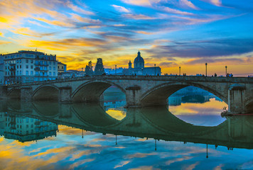 Florence, Ponte alla Carraia medieval Bridge landmark on Arno river at sunset. Tuscany, Italy.