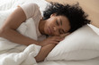 © fizkes - Closeup african woman sleeping in bed at hotel or home