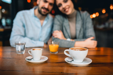 Wall Mural - close up of espresso coffee, romantic couple in blurred background