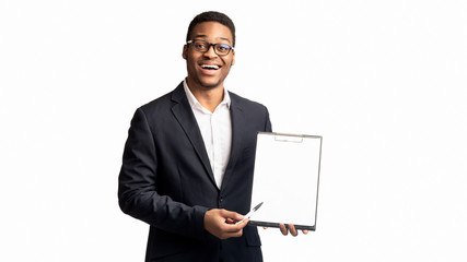 Smiling black guy showing blank clipboard at office