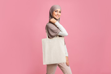 Wall Mural - Arabic Lady In Hedscarf With Blank Eco Bag Over Pink Background