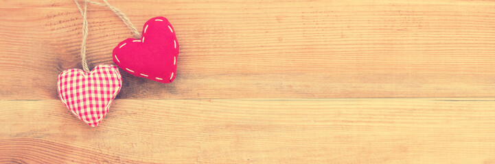 Wall Mural - two red fabric hearts on panoramic wood background, vintage process