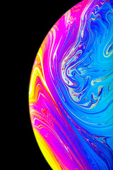 Wall Mural - close up macro photograph of the psychedelic rainbow of colors mixing and swirling in a soap bubble 