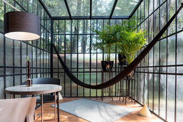 Modern sunroom with a hammock and some plants