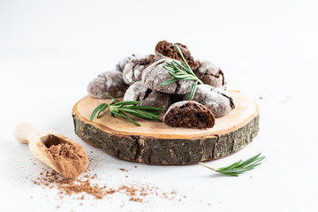 Fresh homemade chocolate cookies with rosemary on decorative wooden tray. Healthy homemade dessert.