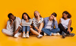 © Prostock-studio - Bored classmates sitting over yellow background, being tired after classes