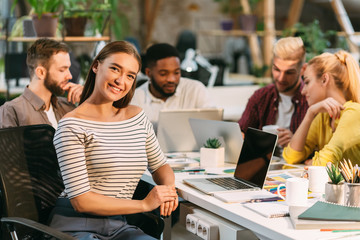 Poster - Female interior designer smiling at camera, working at coworking space