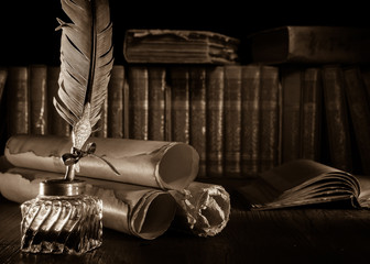 Wall Mural - Quill pen and rolled up papyrus sheets with old books, sepia effect