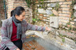 © Juan Alberto Ruiz/ADDICTIVE STOCK - Young lady in casual clothing washing hands in street fountain
