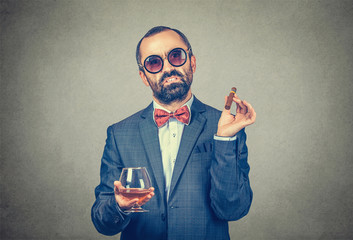 man with a cuban cigar and a glass of wine wearing sunglasses