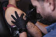 © Raquel Arocena/ADDICTIVE STOCK - Master doing tattoo on forearm of male customer
