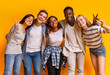 © Prostock-studio - Group of multiracial students smiling and embracing over yellow background