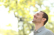 © Antonioguillem - Happy man breathing deep fresh air standing in a park