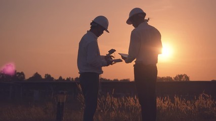 technician and investor using infrared drone technology to inspect solar panels and wind turbines in