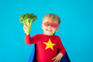 Wall Mural - Superhero child holding broccoli