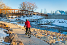 Senior Male Cyclist Is Riding A Bike In Winter Sunset Scenery