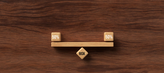 Wall Mural - wooden blocks formed as a seesaw with the word RISK on wooden background