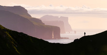 Man Silhouette On Background Of Famous Risin Og Kellingin Rocks And Cliffs Of Eysturoy And Streymoy Islands Seen From Kalsoy Island. Faroe Islands, Denmark. Landscape Photography